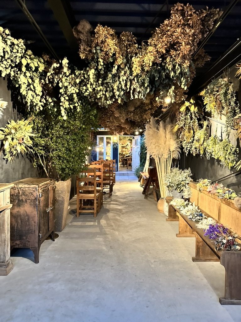天井一面を覆うドライフラワーと、花が並ぶベンチの店内