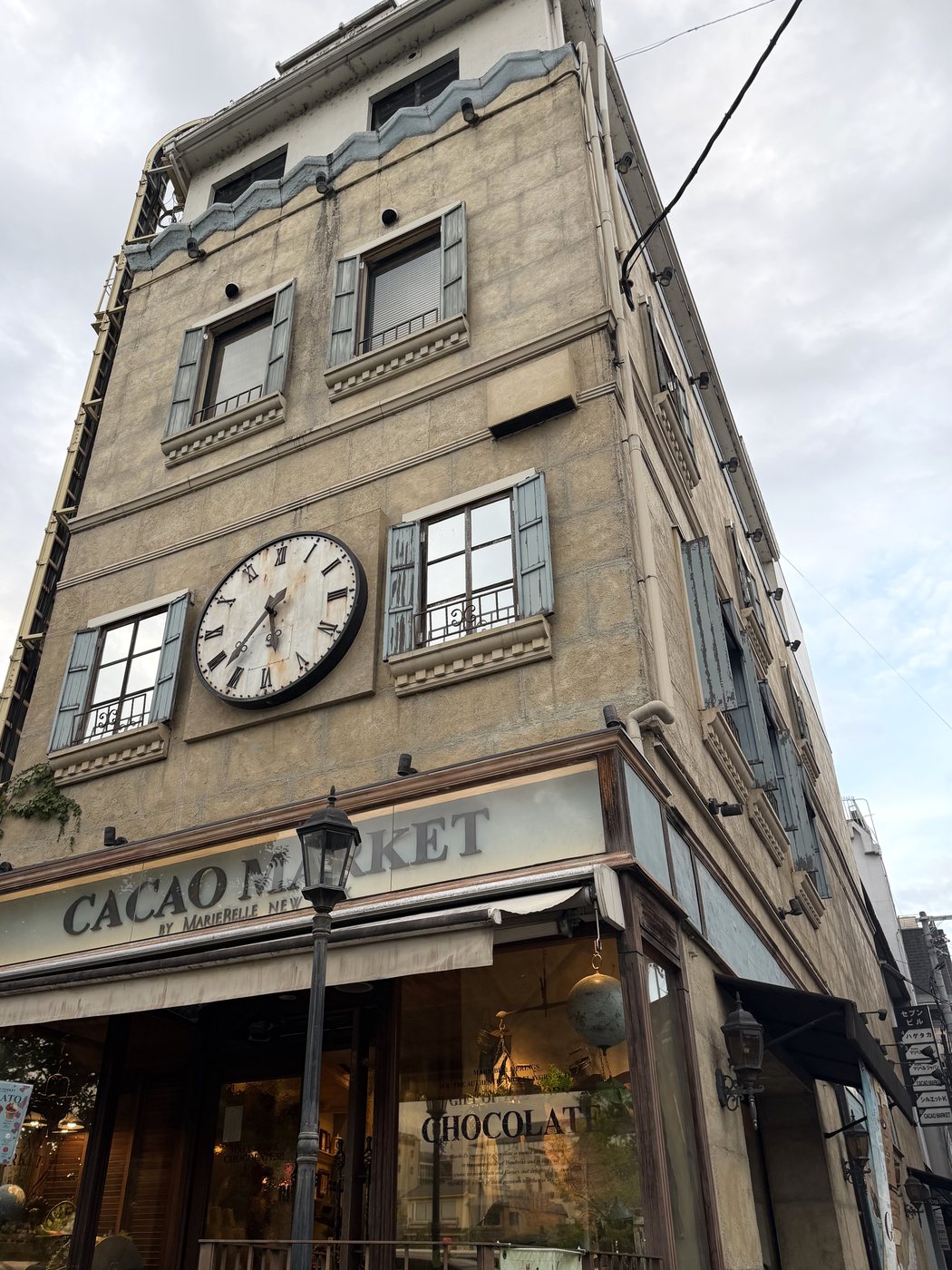 外壁に大時計が掛かるヨーロッパ調のCACAO MARKETの建物