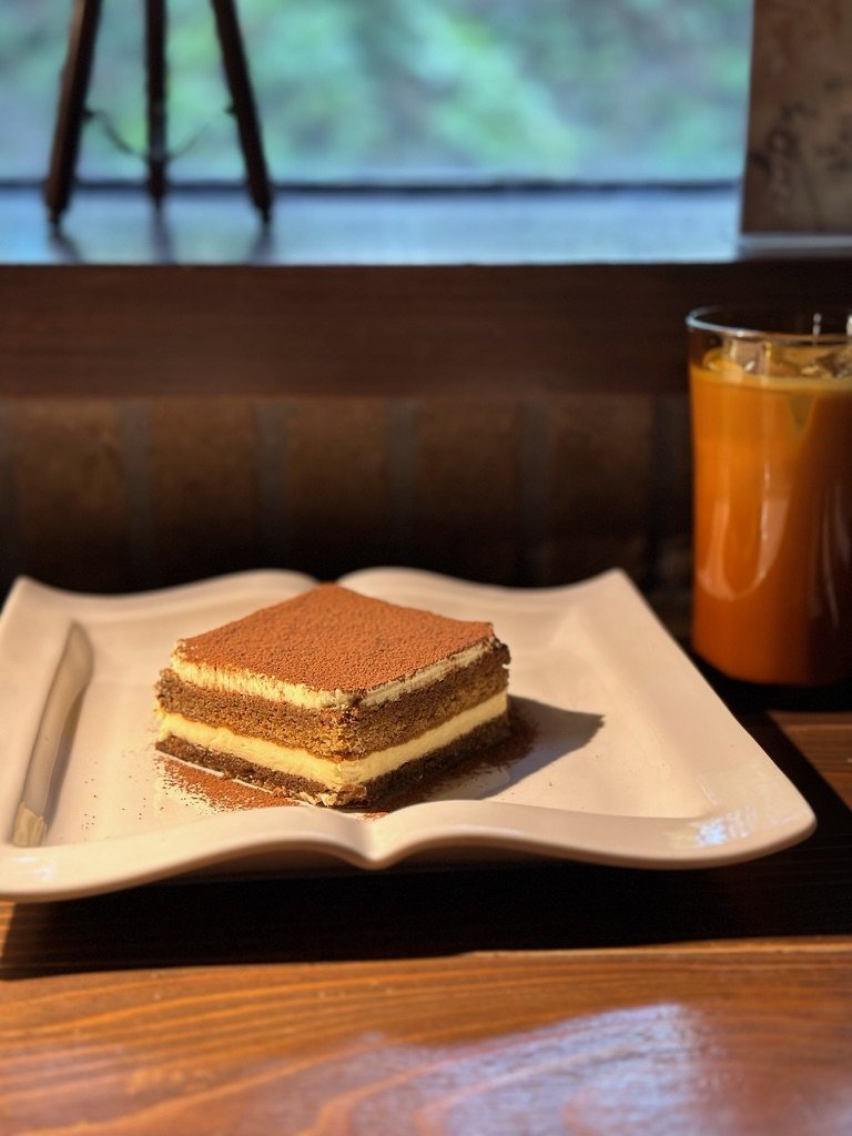本の形をした白い皿に乗ったティラミスと、アイスカフェラテ
