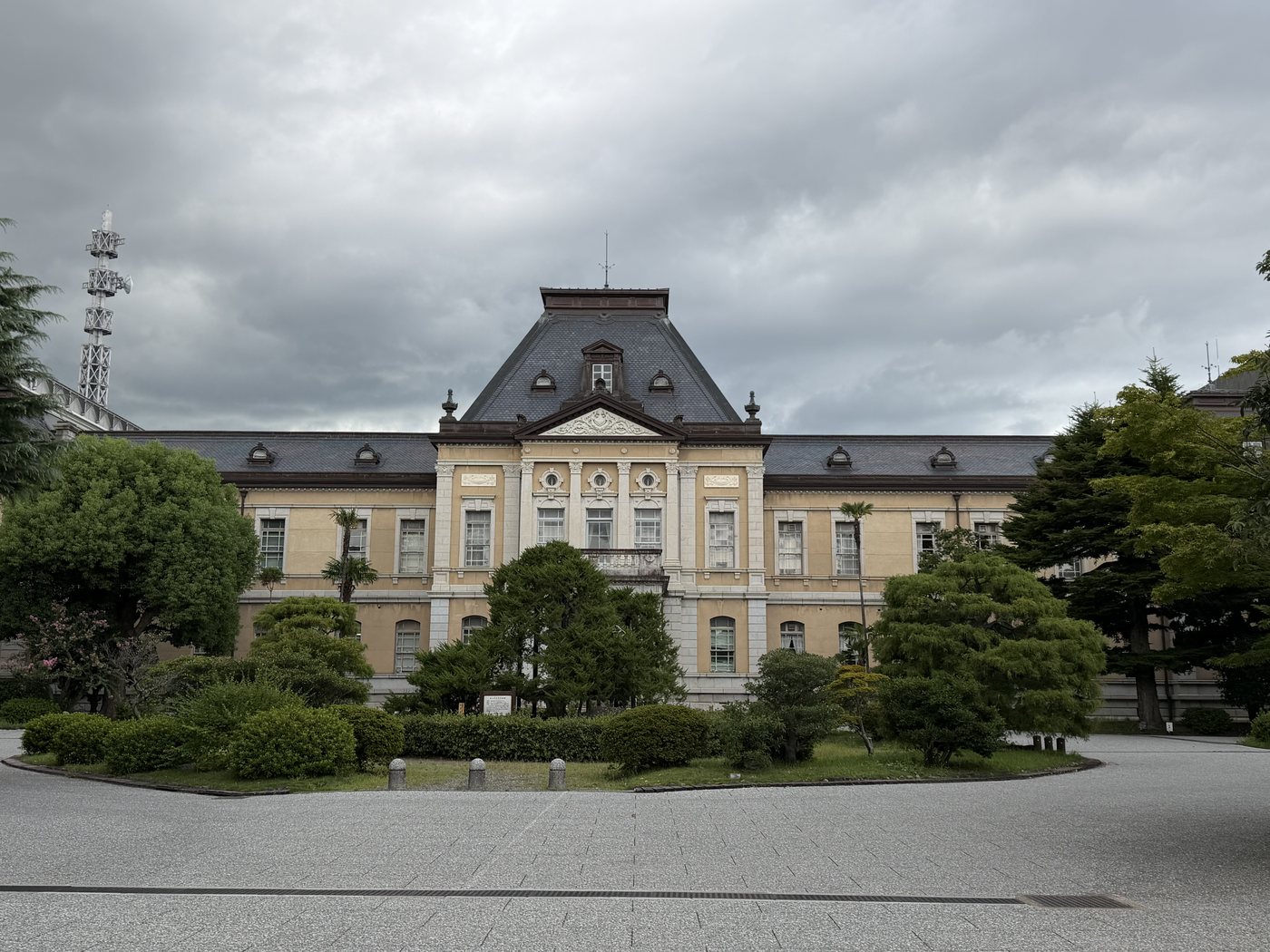 曇り空の下、庭木越しに見る京都府庁旧本館の全景