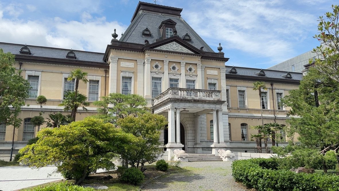 青空の下の京都府庁旧本館の正面外観。ルネサンス様式の煉瓦造2階建て