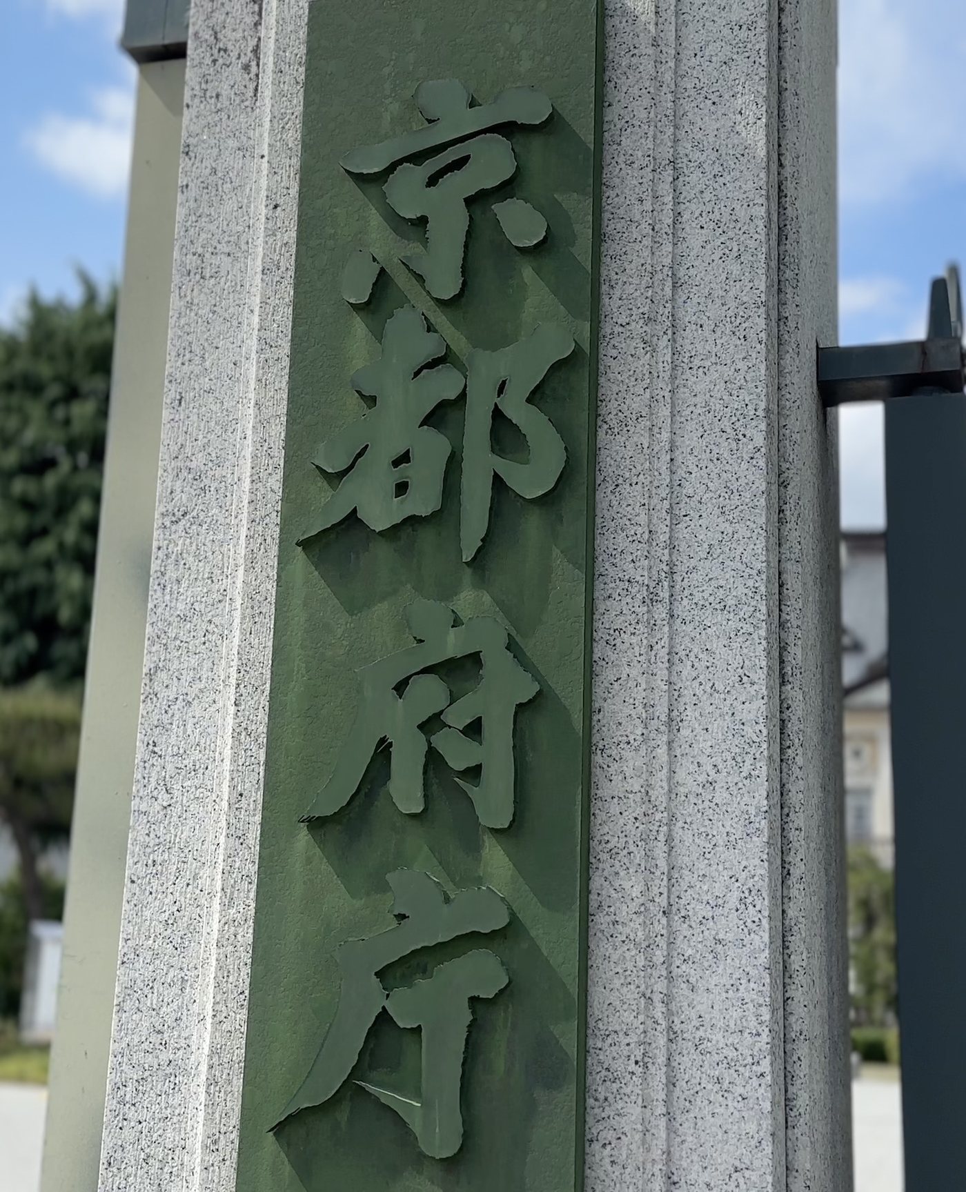 御影石の門柱に掲げられた緑色の「京都府庁」の門標