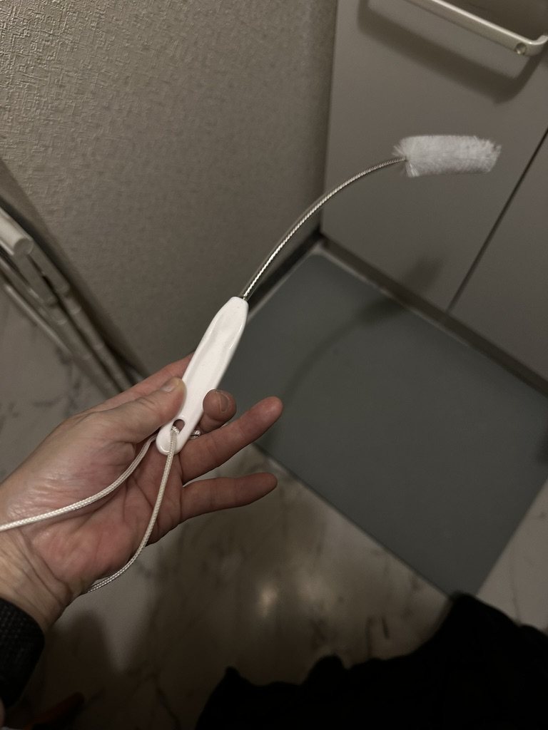 手に持った45cmのスパイラル形状ブラシ。柄に紐が付いている